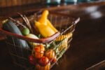 Mesa com cesta de supermercado com alimentos que representando a importância das fibras na alimentação