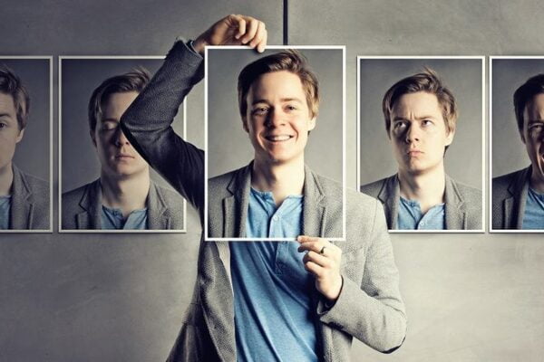 Homem com várias fotos penduradas de si mesmo com diferentes expressões.