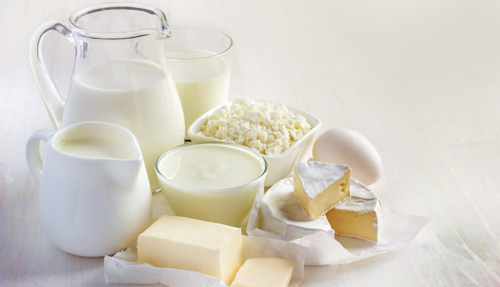 Mesa com diferentes opções de alimentos prebióticos, como leite fermentado, iogurte e queijos.