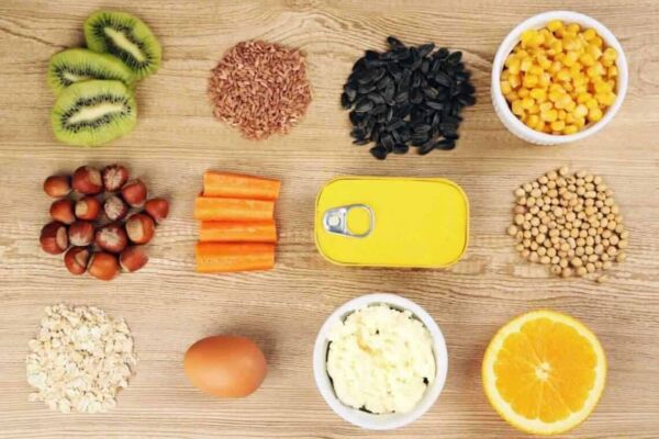 Mesa com alimentos que compõem o complexo B, como frutas, carnes, cereais e legumes.