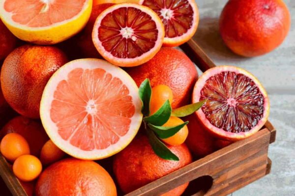 Mesa com uma cesta cheia de laranjas moro e laranjas amargas, que auxiliam no controle de peso.