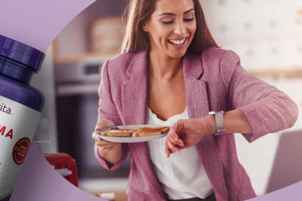 Frasco de Coenzima Q10 com mulher ao fundo com uma prato na mão enquanto confere a hora em seu relógio de pulso.