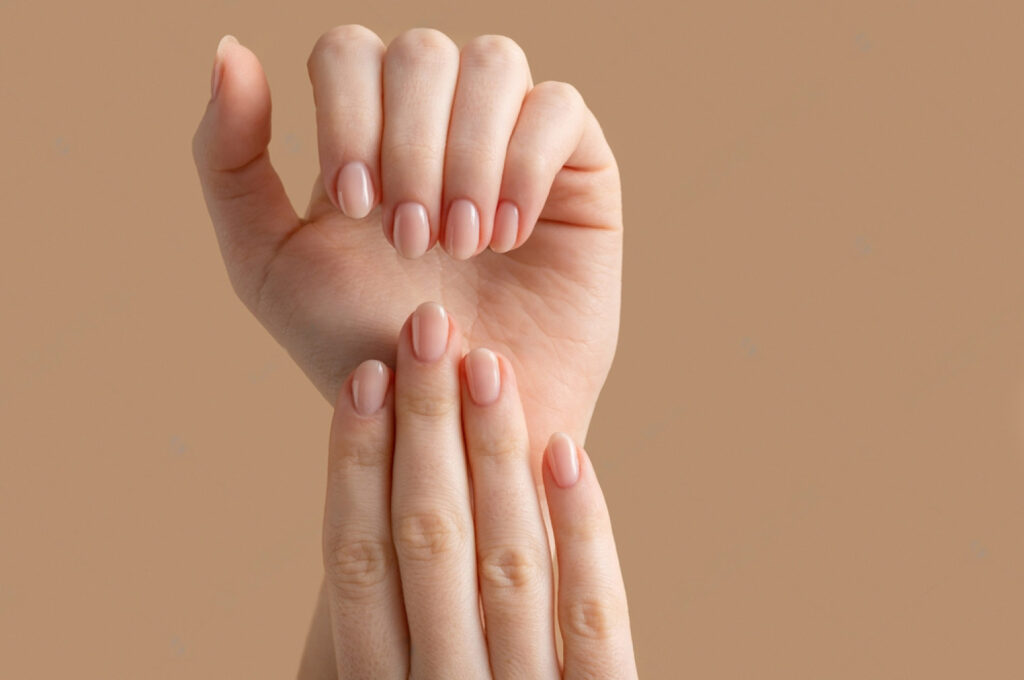 Mãos de uma mulher jovem, com as unhas bonitas e saudáveis