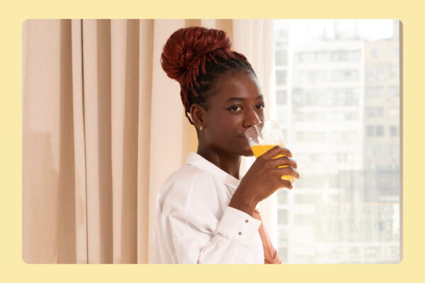 Mulher tomando creatina com sabor da Sanavita.