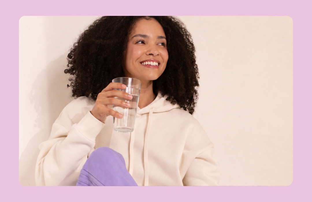 Mulher sorrindo e tomando água para hidratação após uso de GLP-1.